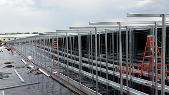 An array of mid-construction Butler Steel frames with scattered construction equipment.