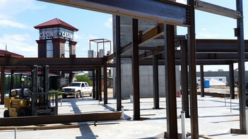 Butler Steel I beams frame the construction of the Catfish Bend Casino. A forklift and a flatbed truck are visible in between the beams.